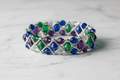 Finished Grace and Gems bracelet with amethyst, emerald, sapphire and crystal beads on marble